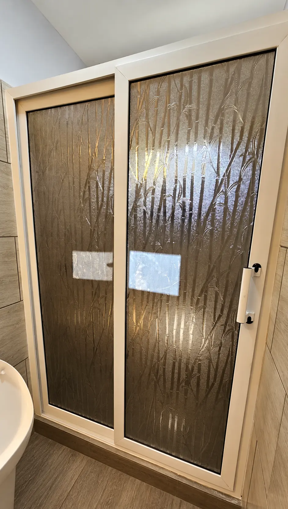 Puerta de baño de dos hojas en PVC blanco con acrílico decorativo texturizado instalada por ALUR